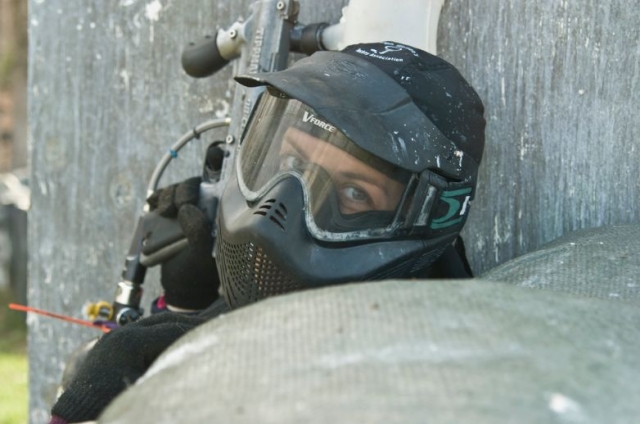 chica escondida para jugar al paintball